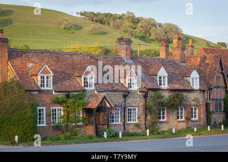 Tradizionale in mattoni e pietra focaia cottages nel villaggio di Turville, Buckinghamshire con Turville collina alle spalle. Foto Stock