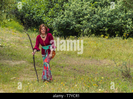 Donna in abito rociero rendendo il titolo di Rocio con sfondo di vegetazione Foto Stock