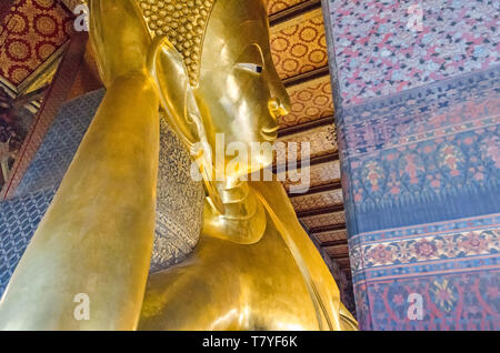 Il braccio destro di supporto della testa con riccioli di Buddha Reclinato, uno dei più grandi statue di Buddha in Thailandia, in un tempio buddista complesso Wa Foto Stock