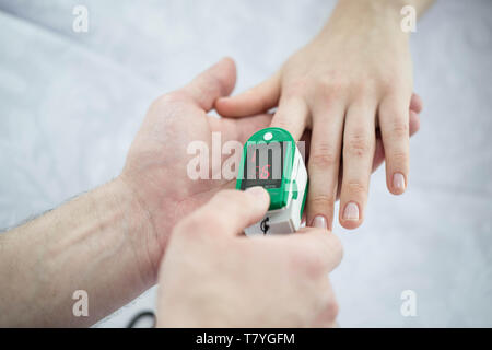 Dito del paziente un tracciato del polso ossimetro di close-up. Impulso di assunzione Foto Stock