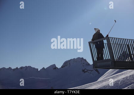 Besucher macht ein Selfie vor dem winterlichen Alpenpanorama auf der Zugspitze Foto Stock