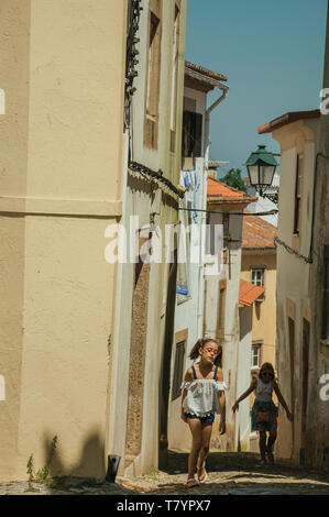 Due bambine camminando lungo il vicolo tra le vecchie case a Castelo de Vide. Bella città medievale con castello in Portogallo confine orientale. Foto Stock