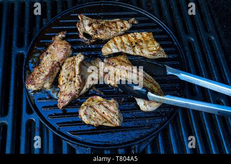 Grigliate di carne di tacchino, Turchia bistecche alla griglia, con barbecue tong, Baviera, Germania Foto Stock