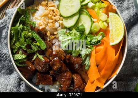 In casa di carne tailandese e ciotola di riso con verdure erbe aromatiche Foto Stock