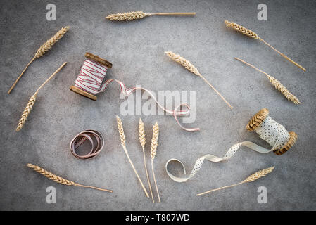 Spighe di grano e vintage bobine di nastro, su sfondo di calcestruzzo. Foto Stock