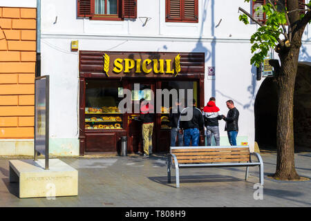 Sibiu, Romania - 21 Aprile 2019: persone in fila per acquistare prodotti di pasticceria da Spicul, una famosa panetteria nel centro di Sibiu (Hermannstadt). Mattina di sole mi Foto Stock