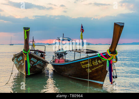 Lunga coda di barche al tramonto sulla spiaggia di Railay in Railay, Ao Nang, Provincia di Krabi, Thailandia, Sud-est asiatico, in Asia Foto Stock