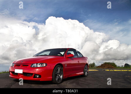 Red Holden Monaro HSV Coupe II 2003 GTO, Vauxhall, Pontiac GTO, Chevrolet Lumina Coupé. Scenic Drive, Waitakere Ranges, Pukematekeo vista di Waitemata Foto Stock