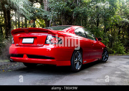 Red Holden Monaro HSV Coupe II 2003 GTO, Vauxhall, Pontiac GTO, Chevrolet Lumina Coupé. Scenic Drive, Waitakere Ranges, Pukematekeo. Shiny auto sportiva. Foto Stock