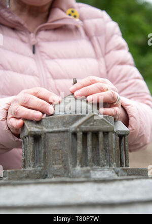 Stuttgart, Germania. Il 10 maggio, 2019. Una donna cieca si sente la miniatura durante l inaugurazione di un cieco modello di Stoccarda cappella funebre. Questo è inteso per consentire a persone non vedenti di sperimentare la cappella funebre su Württemberg toccandola. Credito: Sebastian Gollnow/dpa/Alamy Live News Foto Stock