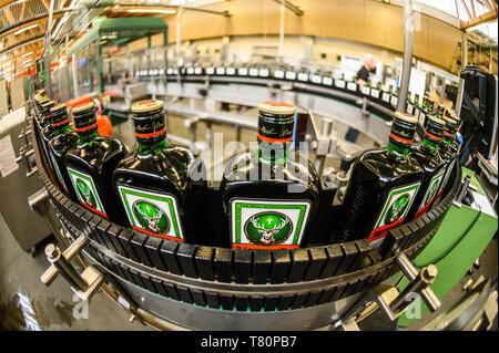 Wolfenbüttel, Germania. Il 10 maggio 2019. Jägermeister bottiglie sono trasportati su un nastro trasportatore in espanso di recente impianto di riempimento del produttore di bevande Jägermeister. Con questa espansione, Jägermeister ha, secondo le proprie informazioni, realizzato uno dei più grandi spiriti di impianti di imbottigliamento in Europa. (Shot con obiettivo fisheye) Foto: Christophe Gateau/dpa Credito: dpa picture alliance/Alamy Live News Foto Stock