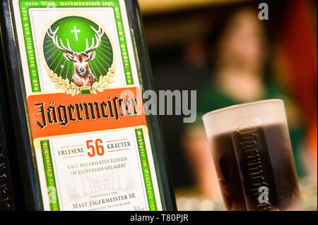 Wolfenbüttel, Germania. Il 10 maggio 2019. Una bottiglia e un bicchiere di grappa alla Jägermeister stand su un contatore all'apertura del recentemente allargato impianto di imbottigliamento della bevanda fabbricante Jägermeister. Con questa espansione, Jägermeister ha, secondo le proprie informazioni, realizzato uno dei più grandi spiriti di impianti di imbottigliamento in Europa. Foto: Christophe Gateau/dpa Credito: dpa picture alliance/Alamy Live News Foto Stock