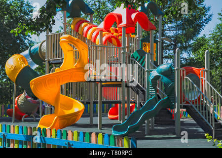 Parco giochi vuota in un parco cittadino in un caldo giorno d'estate e di sole. Foto Stock