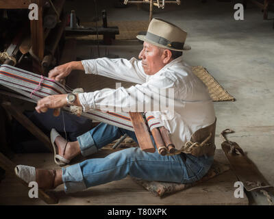 Uomo indigeni tessitura con un telaio dorsalino, Quito, Ecuador, Sud America Foto Stock