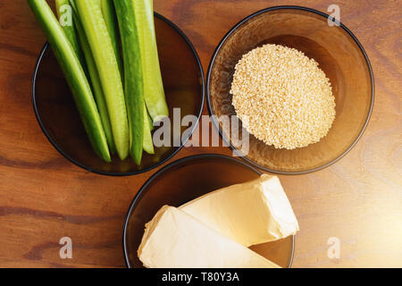 Parte degli ingredienti per la preparazione di sushi in lastre sulla tabella, ossia il riso, formaggio fuso, i cetrioli e i bastoncini di granchio 2019 Foto Stock