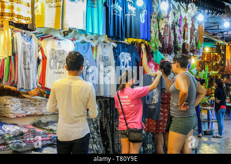 Ragazza turisti sfoglia souvenir vestiti nel centro d'Arte del mercato di notte nel centro di questo NW città turistica, Siem Reap, Cambogia, Indocina, Asia Foto Stock