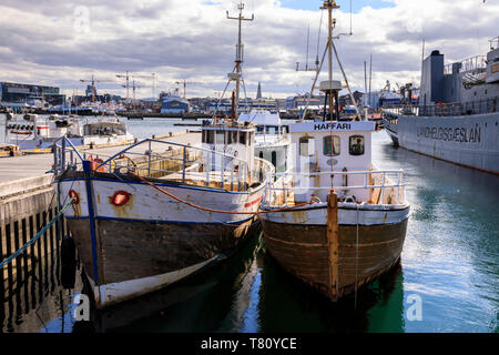Barche da pesca in Reykjavik vecchio porto in estate, distante Hallgrimskirkja, centro di Reykjavik, Islanda, regioni polari Foto Stock