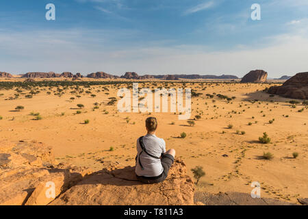 Donna godendovi lo splendido paesaggio, Ennedi altopiano, Sito Patrimonio Mondiale dell'UNESCO, la regione di Ennedi, Ciad, Africa Foto Stock