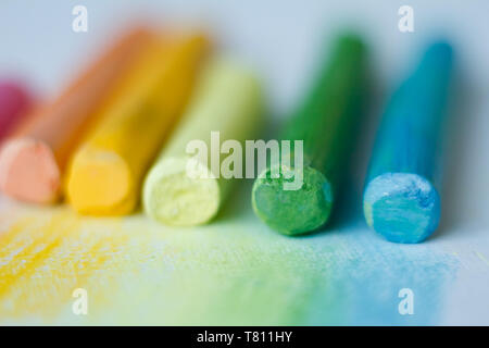 Extreme close-up di variopinti gessi pastello su una superficie bianca, il fuoco selettivo Foto Stock