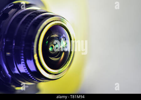 Vista laterale della telecamera con retroilluminazione di colore giallo. Fotografia orizzontale Foto Stock