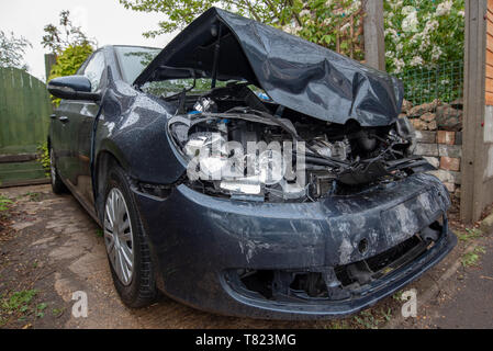 Car crash, blu/grigio Volkswagen Golf veicolo nastro della polizia e danni da vicino. Incidente auto sfondo. Foto Stock