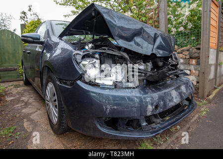 Car crash, blu/grigio Volkswagen Golf veicolo nastro della polizia e danni da vicino. Incidente auto sfondo. Foto Stock
