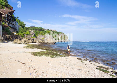 Pescatore che trasportano un netto a piedi lungo Bingin Beach, Bali, Indonesia Foto Stock