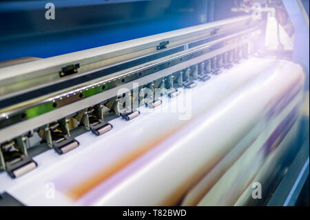 Grande stampante a getto di inchiostro con la stampa su carta di vinile con illuminazione nel posto di lavoro Foto Stock