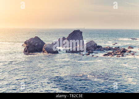 Tramonto sul mare. Le onde e le rocce. questa foto orizzontale appare come una carta da una destinazione turistica. Foto Stock