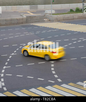 Taxi giallo si muove sulla strada di città Foto Stock