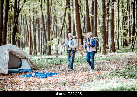 Coppia senior a piedi nelle vicinanze del campeggio nella foresta. Concetto di uno stile di vita attivo su pensionamento Foto Stock