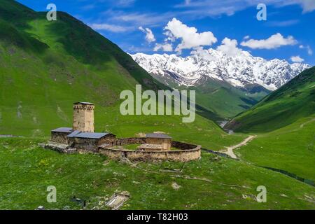 La Georgia, Svaneti superiore (Zemo Svaneti), villaggio di Ushguli, classificato come patrimonio mondiale dall UNESCO, Lamaria la chiesa di Santa Maria di Ushguli dal XII secolo e il Monte Chkhara (picco massimo in Georgia con 5193 m) sullo sfondo (vista aerea) Foto Stock