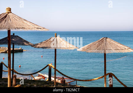 In vimini solitario ombrellone in spiaggia mediterranea dal mare