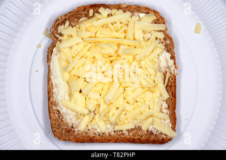 Formaggio Cheddar grattugiato con Branston pickle sul pane integrale Foto Stock