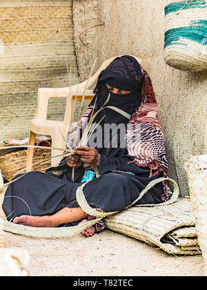 Una lingua Swahili Lady rendendo stuoie tessute Foto Stock