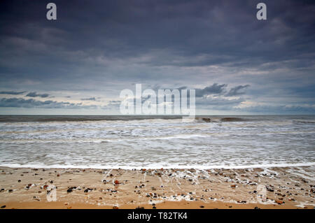 Una vista di una radura showery cielo sopra il mare dalla spiaggia di Happisburgh, Norfolk, Inghilterra, Regno Unito, Europa. Foto Stock