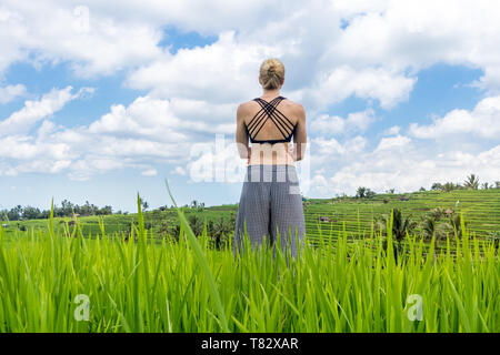 Rilassato e informale donna sportivo godendo di natura pura in splendidi e verdi risaie di Bali. Foto Stock