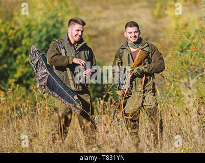 I cacciatori di uomo con un fucile pistola. Boot camp. Abilità di caccia e di apparecchiature di arma. Come ruotare la caccia in hobby. Uniforme militare di moda. Amicizia di uomini cacciatori. Cacciatori con fucili rilassante Foto Stock