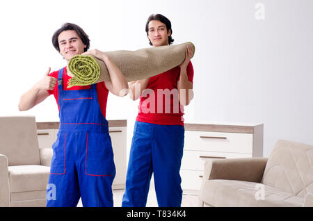 Due giovani contraente i dipendenti che si spostano oggetti personali Foto Stock