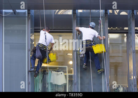 Le rondelle di finestra di pulizia dei vetri del centro per lo shopping Foto Stock