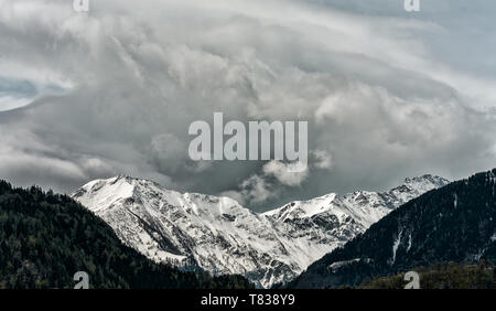 Panorama del paesaggio di montagna con cime innevate e espressiva cloudscape Foto Stock