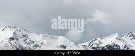 Panorama del paesaggio di montagna con cime innevate e espressiva cloudscape Foto Stock