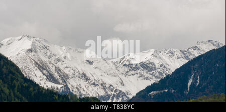 Panorama del paesaggio di montagna con cime innevate e espressiva cloudscape Foto Stock
