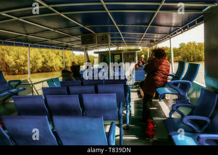 Riserva Naturale Delta del Danubio. La Romania. Aprile 20, 2019. Una nave da crociera nuota lungo il fiume. I turisti sul ponte guardarsi intorno. Foto Stock