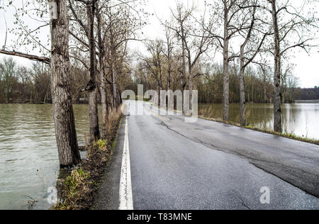 Acqua alta: il livello di acqua quasi raggiunge il bordo di una stretta strada rialzata che attraversa il lato sud del Lago Champlain in una piovosa giornata di primavera nel Vermont. Foto Stock