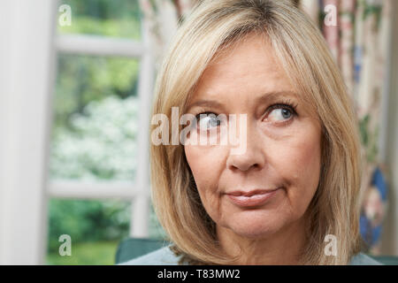 Testa e spalle colpo di premurosa donna matura a casa Foto Stock