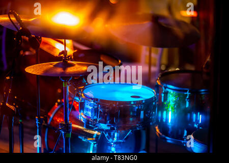 Vuoto di luce astratta stadio illuminato con drumkit e microfono. Tamburi di luce multicolore durante le feste sul palco. Foto Stock