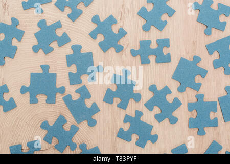 Vista superiore del blu i pezzi del puzzle sparsi sul tavolo di legno Foto Stock