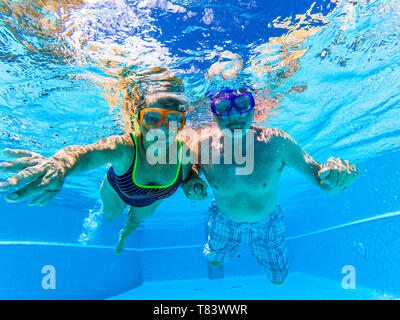 Le persone a divertirsi e godere di nuotare sott'acqua nella piscina con blu chiaro acqua intorno - Summer Holiday Vacation Resort hotel concept per il turista Foto Stock