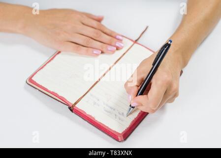 La scrittura a mano in notebook aperto sulla tavola Foto Stock